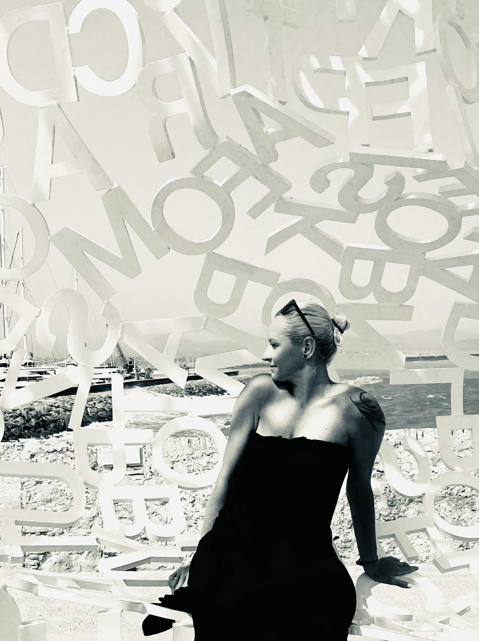 Portrait among letter sculpture by the coast